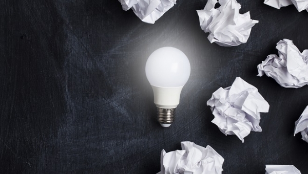 Inspiration and imagination concept. lightbulb with white crumpled paper documents