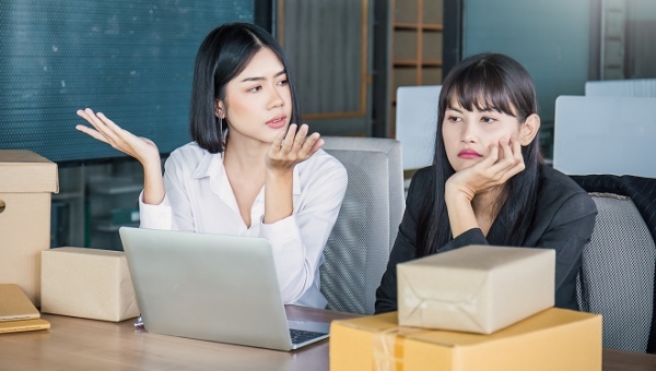 Bored,two business woman sitting discussion on the desk. Freelance woman working overload, Young Asian small business owner at home office, online marketing packing box and delivery, SME concept